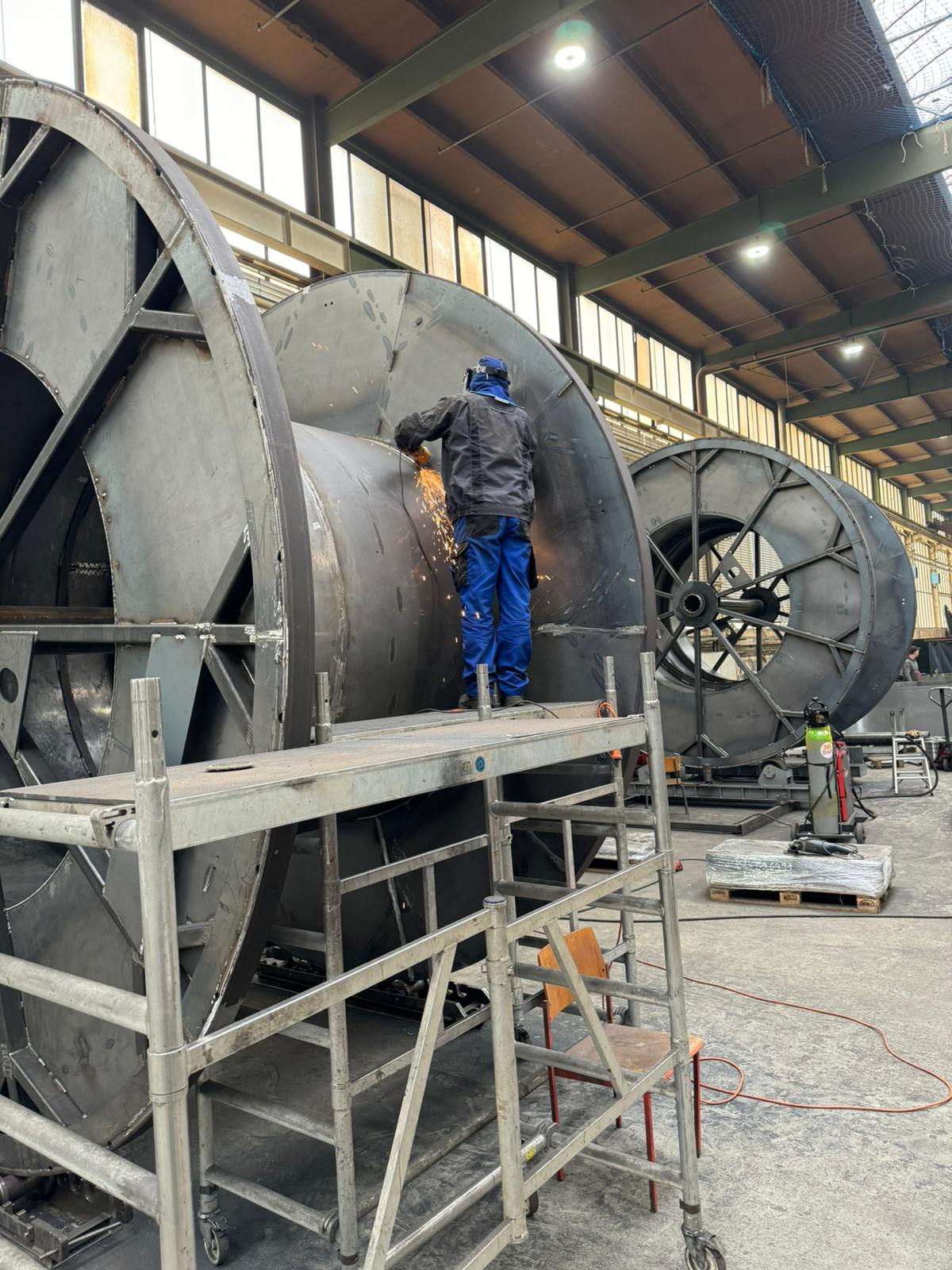 Welder grinding on a massive industrial steel structure
